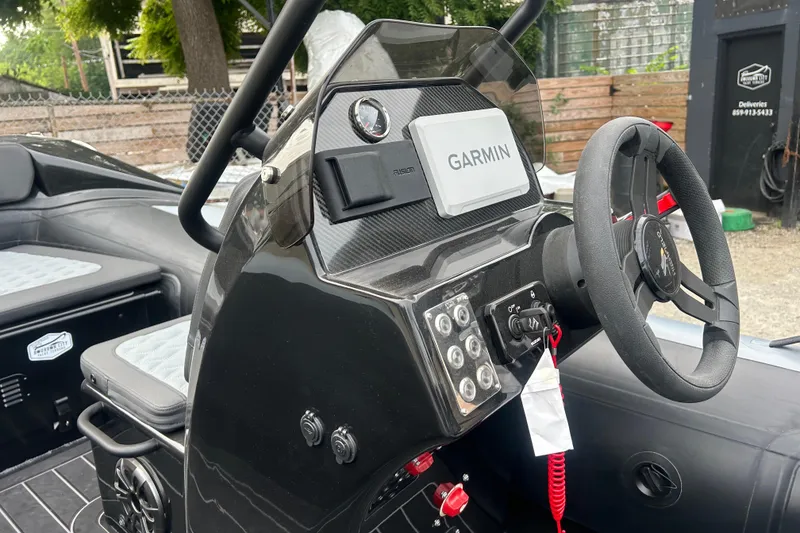 Slide: The Image of 2025 Highfield Sport 390 boat dashboard with Garmin navigation system and steering wheel. - 8