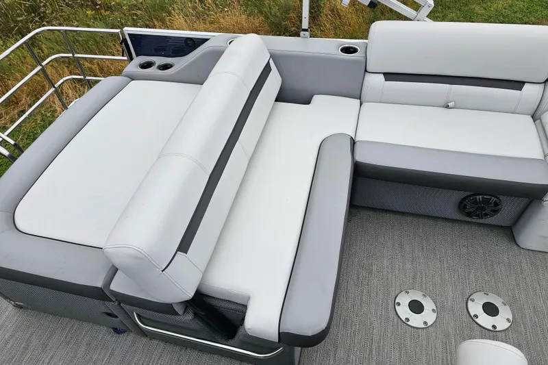 Slide: The Image of 2022 Sweetwater 2286 SFL boat interior with gray and white cushioned seating. - 12