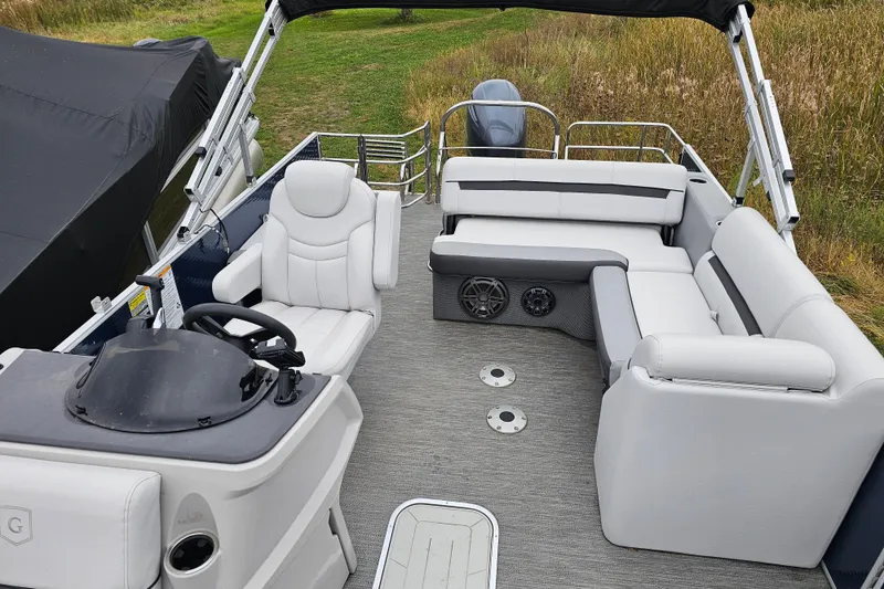 Slide: The Image of 2022 Sweetwater 2286 SFL pontoon boat interior with plush seating and steering console. - 7