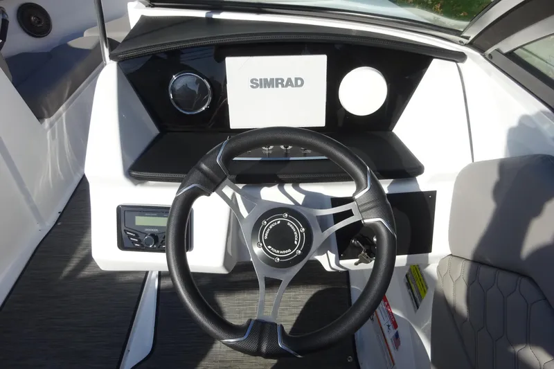 Slide: The Image of 2024 Four Winns H1 OB boat dashboard with steering wheel and Simrad display. - 12