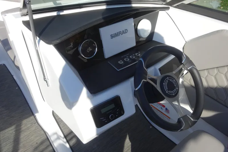 Slide: The Image of 2024 Four Winns H1 OB boat dashboard with steering wheel and Simrad display. - 13