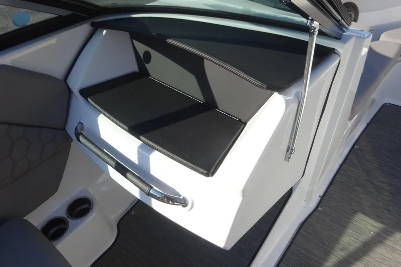 Slide: The Image of 2024 Four Winns H1 OB boat interior with storage compartment and cup holders. - 16