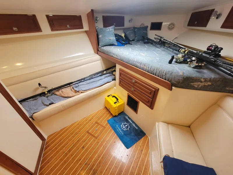 Slide: The Image of Interior of 2006 Carolina Classic 32 Express boat with fishing rods and cozy seating. - 13
