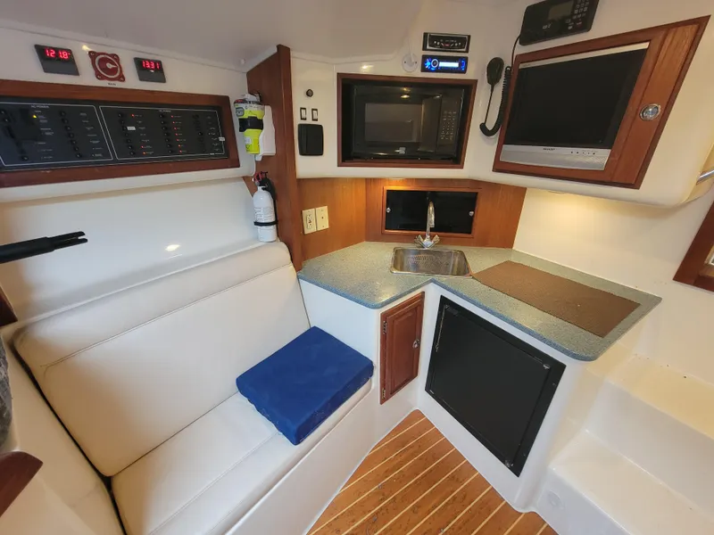 Slide: The Image of Interior of 2006 Carolina Classic 32 Express boat with kitchenette and seating area. - 14
