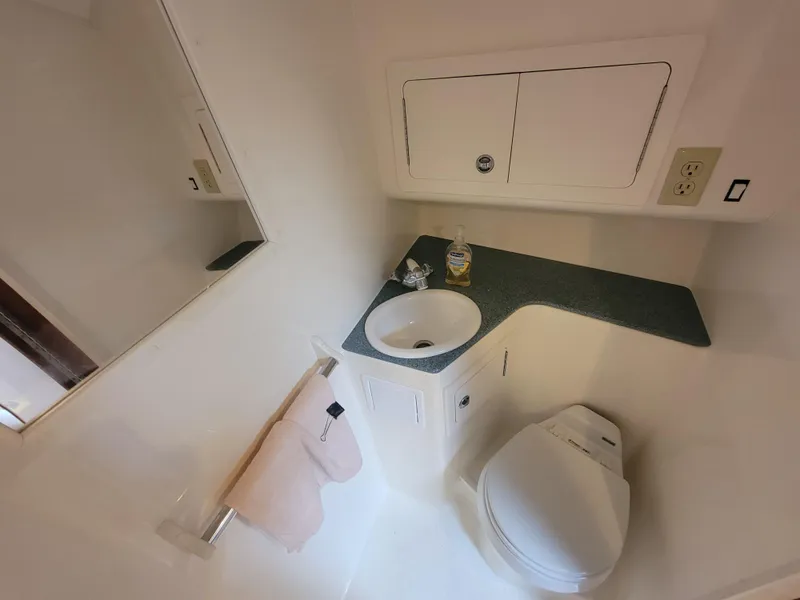 Slide: The Image of 2006 Carolina Classic 32 Express bathroom with sink, toilet, and storage cabinets. - 16