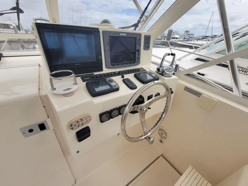 Slide: The Image of 2006 Carolina Classic 32 Express helm with navigation screens and steering wheel. - 9