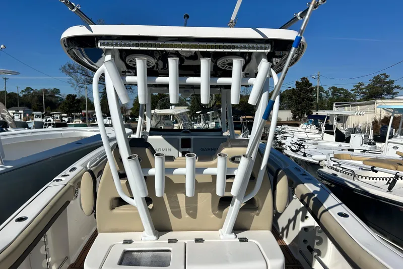 Slide: The Image of 2020 Tidewater 320 CC Adventure boat with rod holders and seating, docked in a marina. - 16