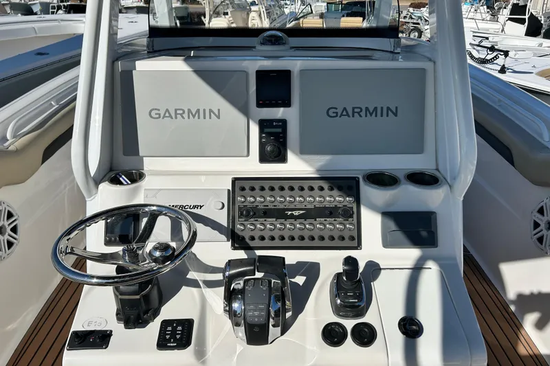 Slide: The Image of 2020 Tidewater 320 CC Adventure boat dashboard with Garmin displays and Mercury controls. - 18
