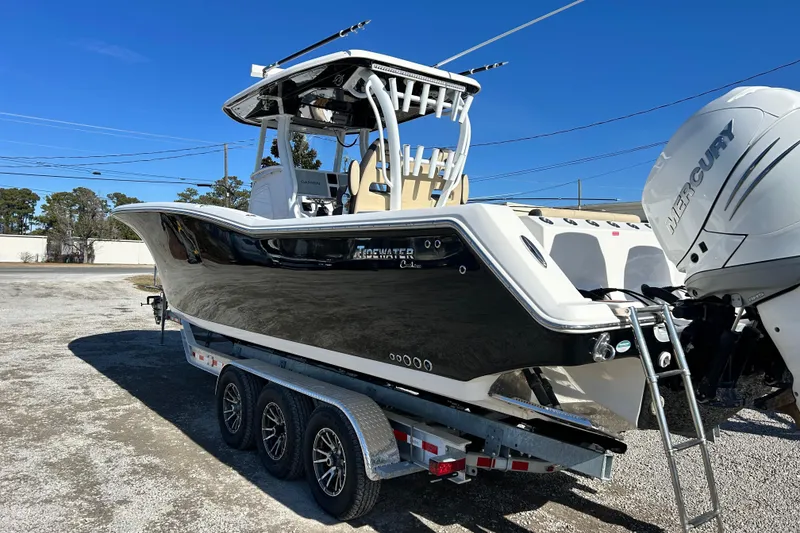 Slide: The Image of 2020 Tidewater 320 CC Adventure boat on trailer with Mercury engines, parked outdoors. - 5