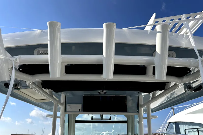 Slide: The Image of 2023 Boston Whaler OUTRAGE boat with rod holders under clear blue sky. - 10