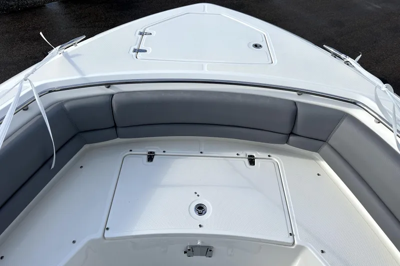 Slide: The Image of 2023 Boston Whaler OUTRAGE boat interior with cushioned seating and storage compartment. - 14