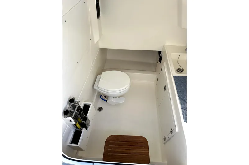 Slide: The Image of 2023 Boston Whaler OUTRAGE boat interior with toilet and storage compartments. - 16
