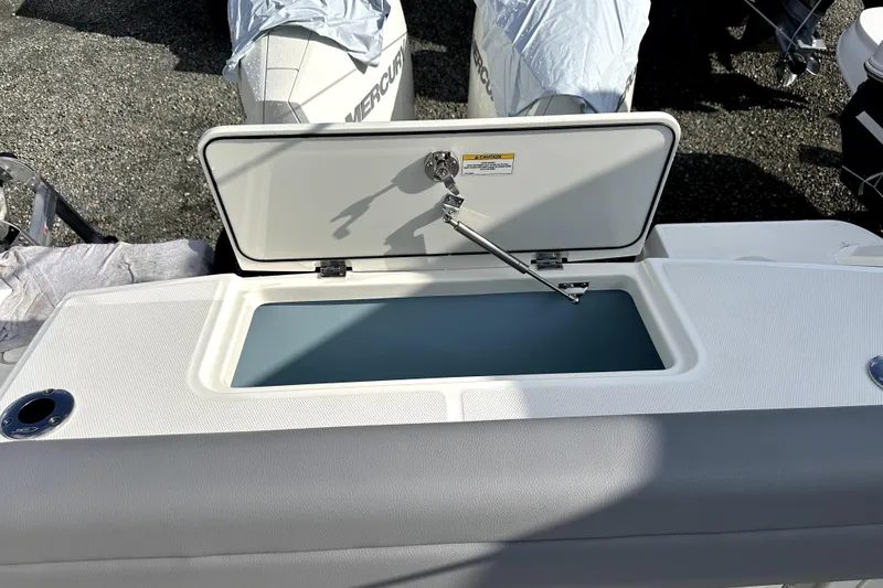 Slide: The Image of 2023 Boston Whaler OUTRAGE boat with open storage compartment, showcasing sleek design. - 18