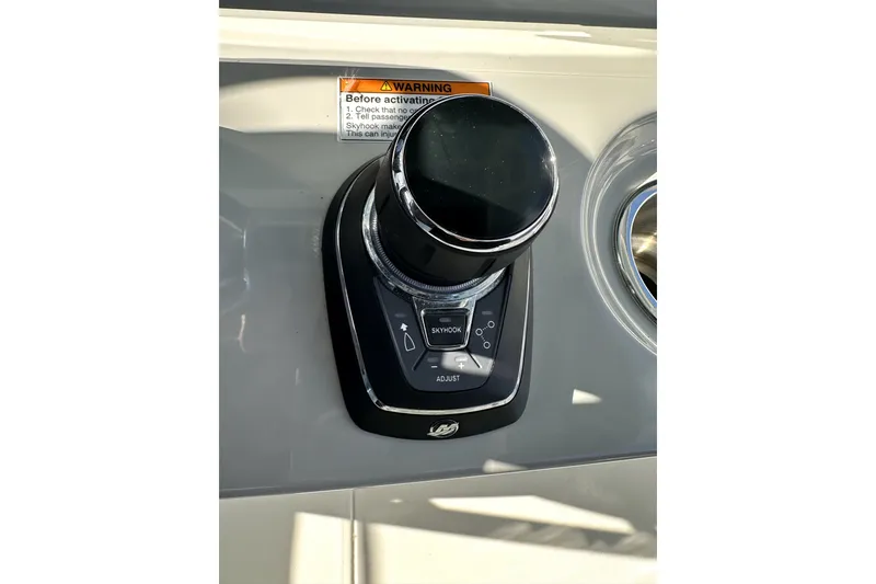Slide: The Image of 2023 Boston Whaler OUTRAGE boat control panel with joystick and warning label. - 22