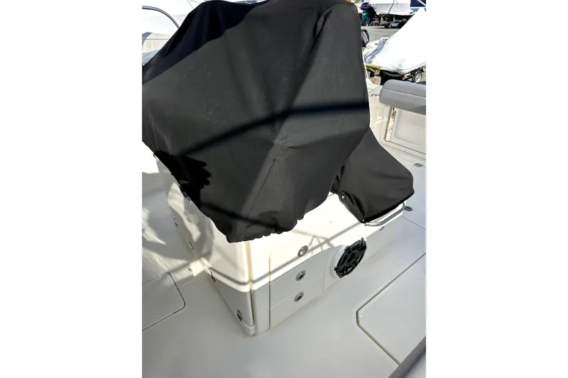 Slide: The Image of 2023 Boston Whaler OUTRAGE boat interior with covered console and seating area. - 8