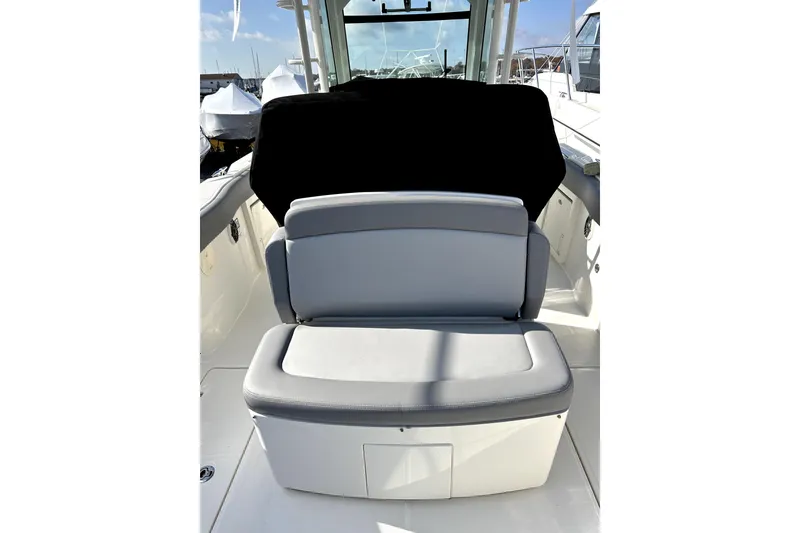 Slide: The Image of 2023 Boston Whaler OUTRAGE boat interior with cushioned seating and sleek design. - 9