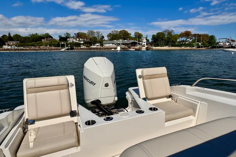 Slide: The Image of 2022 Boston Whaler 220 Dauntless boat with Mercury engine on calm water. - 2