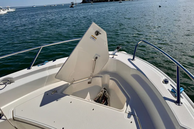 Slide: The Image of 2022 Boston Whaler 220 Dauntless boat with open storage compartment on calm water. - 8