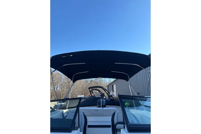 Slide: The Image of 2023 Searay SPX 210 OB boat with canopy under clear blue sky. - 16