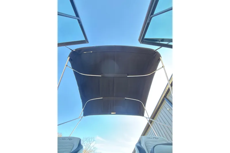 Slide: The Image of 2023 Searay SPX 210 OB boat canopy viewed from below, clear sky background. - 17