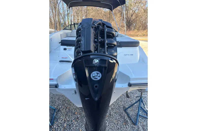 Slide: The Image of 2023 Searay SPX 210 OB boat with powerful outboard motor, parked on gravel. - 27