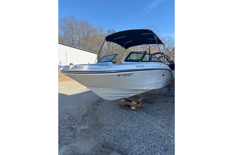Slide: The Image of 2023 Searay SPX 210 OB boat with canopy, parked on gravel. - 4