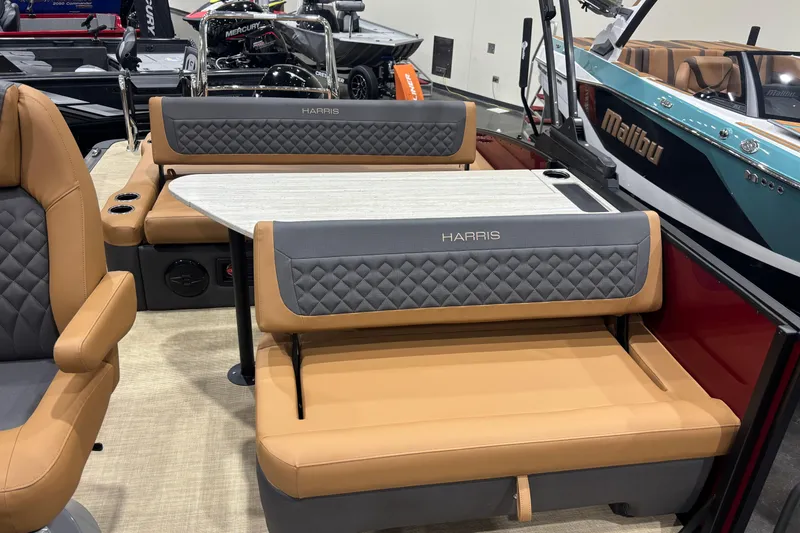 Slide: The Image of 2026 Harris Sunliner 230 boat interior with tan and gray seating, featuring a central table. - 10