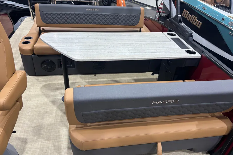 Slide: The Image of 2026 Harris Sunliner 230 boat interior with tan and gray seating, table, and cup holders. - 11