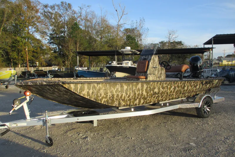 The Image of Camouflage-patterned 2026 Avid 21 Recon ST boat on a trailer in a sunny outdoor setting. - 0