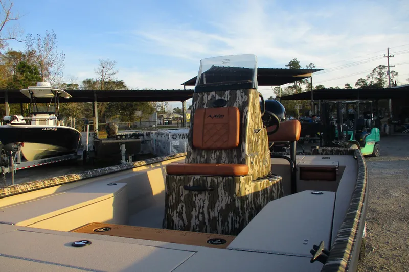 Slide: The Image of 2026 Avid 21 Recon ST boat with camo design, parked outdoors in a marina setting. - 2