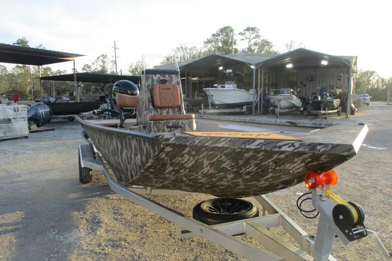 Slide: The Image of Avid 21 Recon ST 2026 boat with camouflage design on a trailer at a dealership. - 3