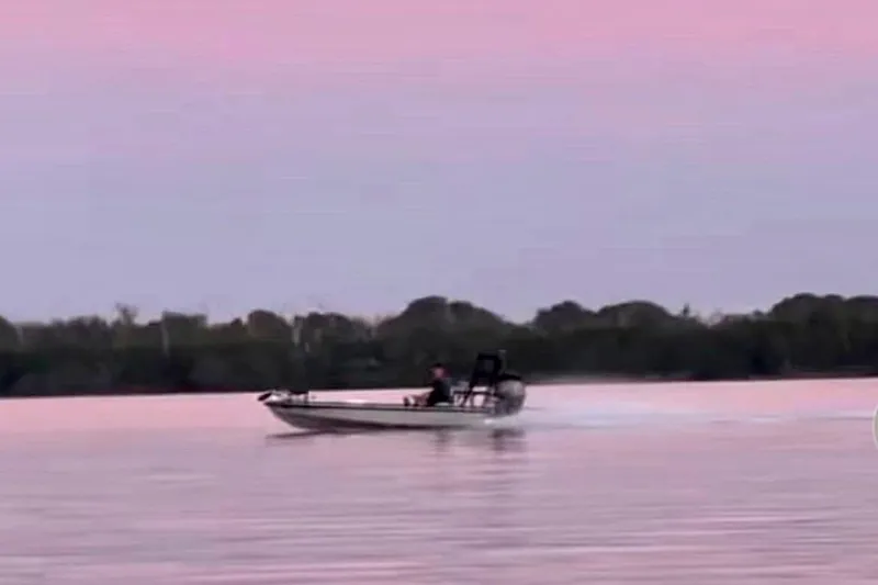 Slide: The Image of Dusky 16 Custom boat on serene pink water at sunset, 2017 model. - 5