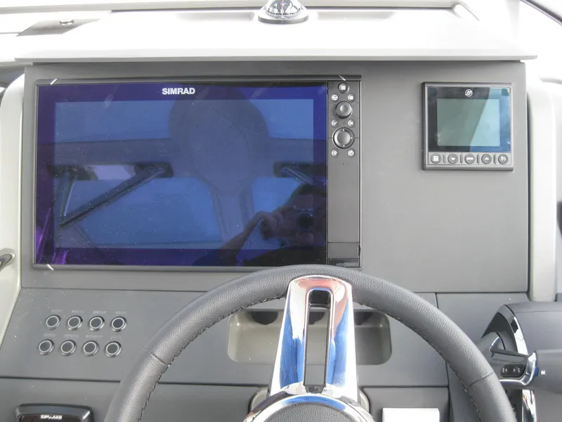 Slide: The Image of 2024 Nimbus T9 boat dashboard with Simrad display and steering wheel. - 22