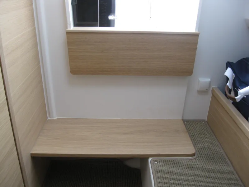 Slide: The Image of Interior of 2024 Nimbus T9 boat with wooden bench and storage area. - 32