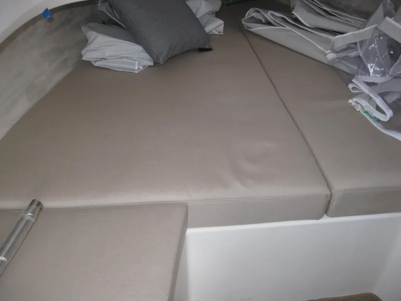 Slide: The Image of 2024 Nimbus T9 boat cabin with beige cushions and pillows. - 30