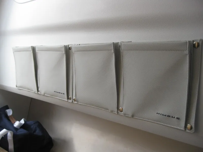 Slide: The Image of Four gray storage pouches on Nimbus T9 2024 boat interior wall. - 31
