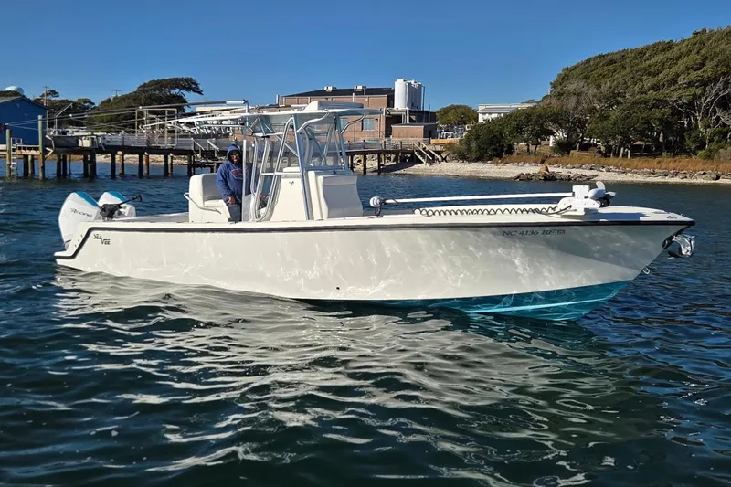 The Image of 2017 SeaVee 320B boat on water near dock and trees. - 0