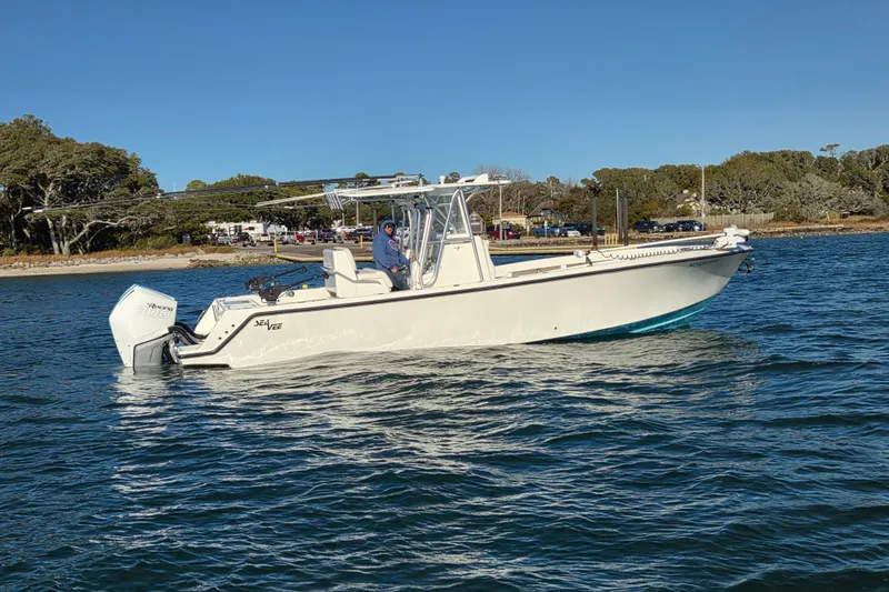 Slide: The Image of 2017 SeaVee 320B boat on water, clear sky, coastal background. - 12