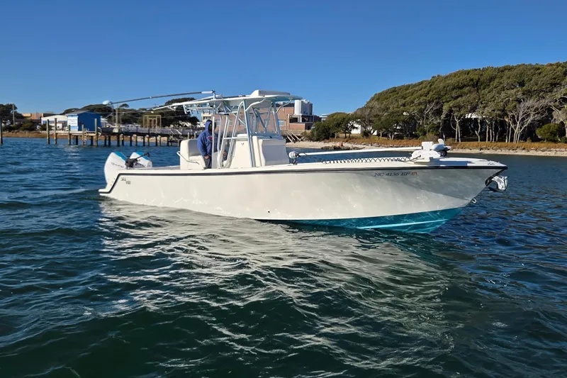 Slide: The Image of 2017 SeaVee 320B boat on calm water near a dock and trees. - 3