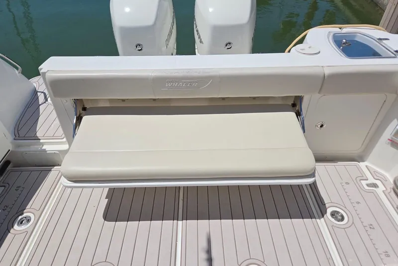 Slide: The Image of 2016 Boston Whaler 315 Conquest boat with foldable bench seat and twin engines. - 10
