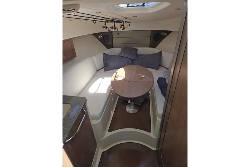 Slide: The Image of 2016 Boston Whaler 315 Conquest cabin interior with cozy seating and table. - 11