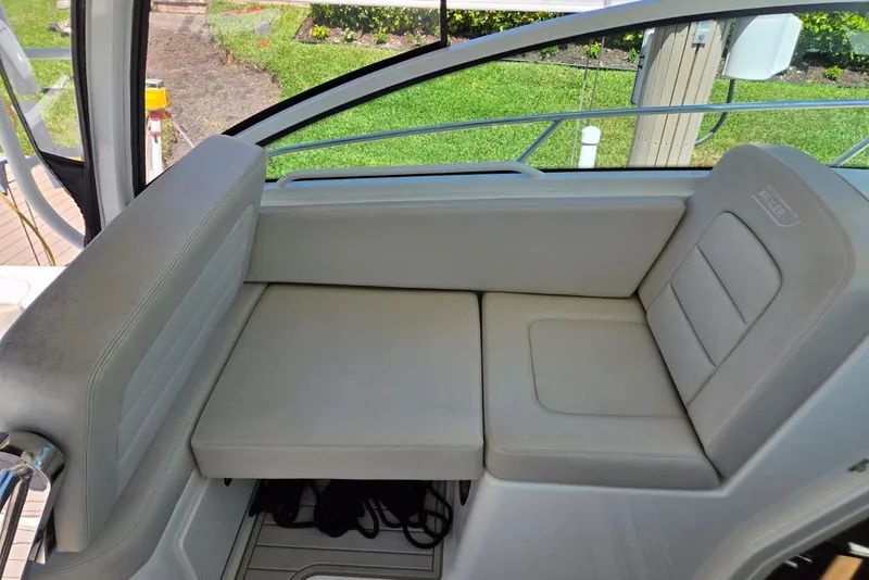 Slide: The Image of 2016 Boston Whaler 315 Conquest interior seating, featuring comfortable beige upholstery. - 6