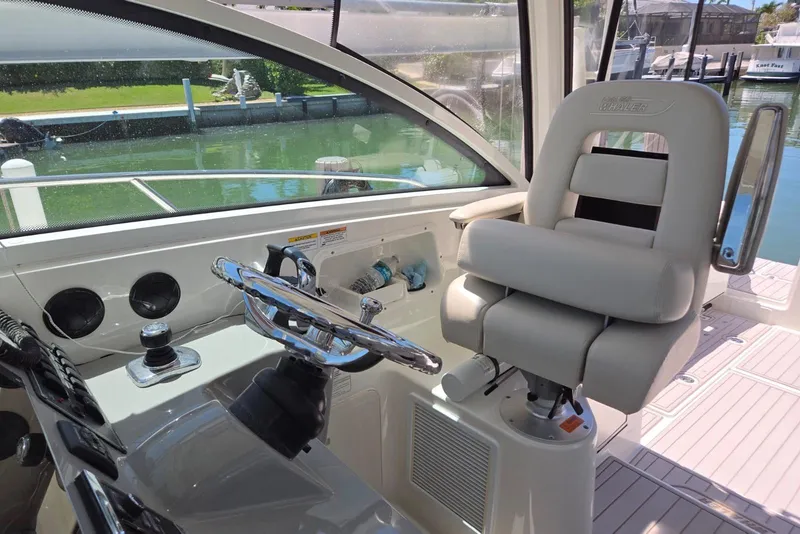 Slide: The Image of Helm of 2016 Boston Whaler 315 Conquest with plush captain's chair and steering wheel. - 8