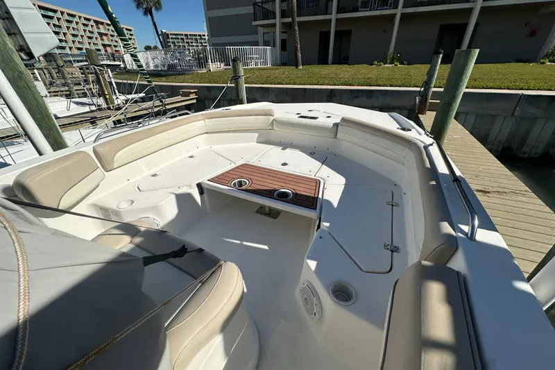 Slide: The Image of 2017 NauticStar 211 Angler boat interior with seating and table at dock. - 2