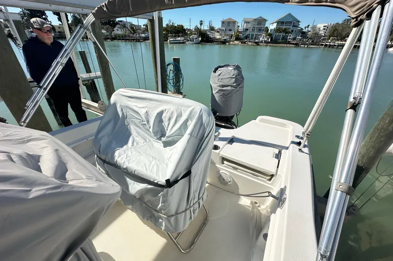 Slide: The Image of 2017 NauticStar 211 Angler boat with covered seats docked by waterfront homes. - 9