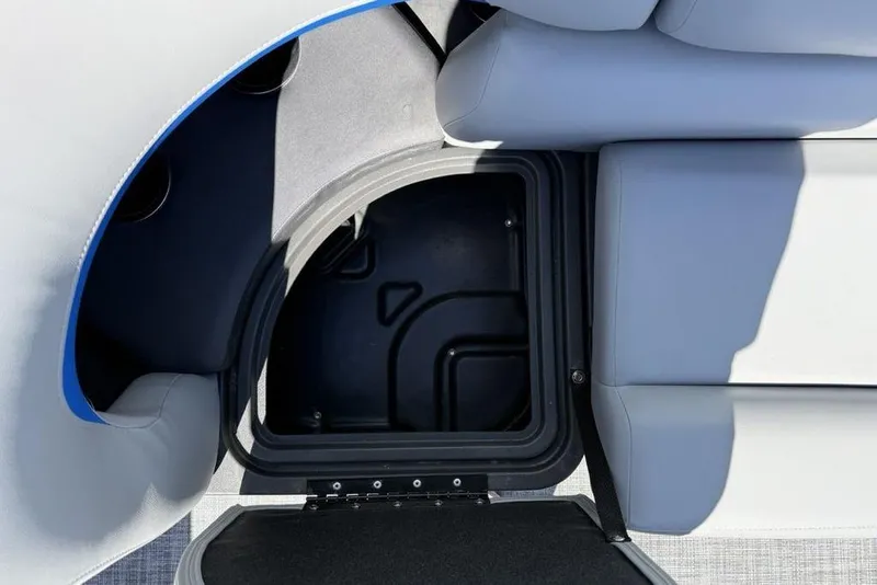 Slide: The Image of 2026 Sun Tracker Party Barge 20 DLX storage compartment with gray seating. - 13