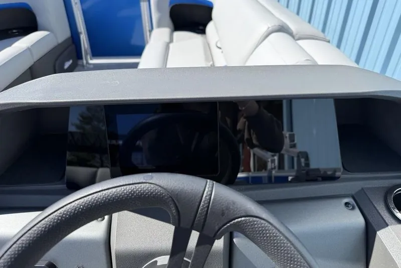 Slide: The Image of 2026 Sun Tracker Party Barge 20 DLX dashboard with steering wheel and seating. - 16