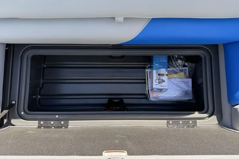 Slide: The Image of 2026 Sun Tracker Party Barge 20 DLX storage compartment with manuals and documents. - 17