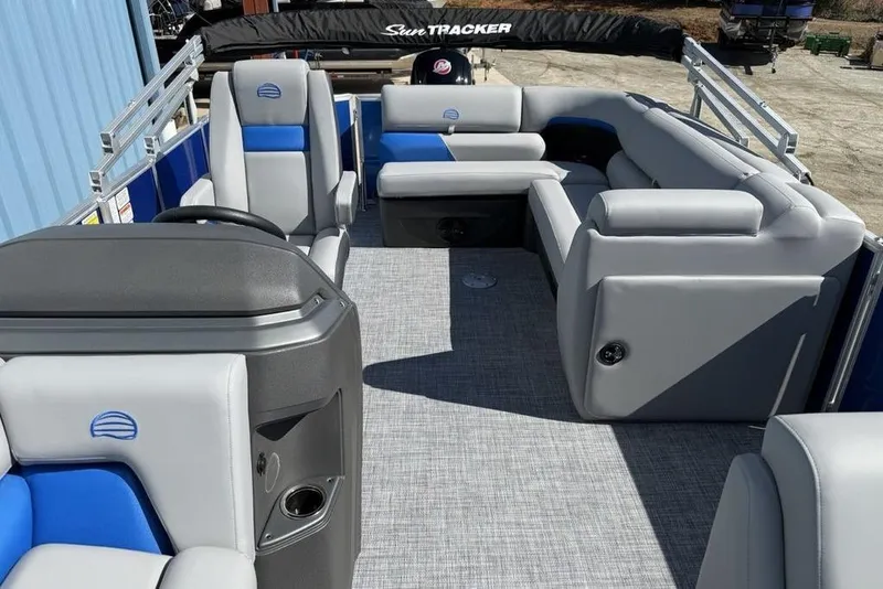 Slide: The Image of 2026 Sun Tracker Party Barge 20 DLX interior with gray and blue seating, spacious layout. - 21