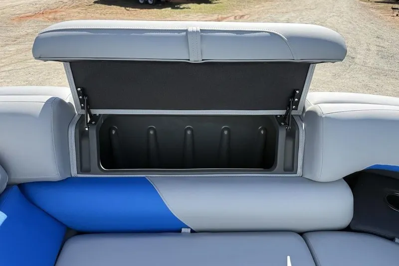 Slide: The Image of 2026 Sun Tracker Party Barge 20 DLX storage compartment with open lid, showcasing interior space. - 6